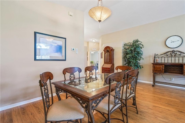 dining space with baseboards and light wood finished floors