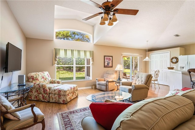 living room with visible vents, a healthy amount of sunlight, ceiling fan, and wood finished floors