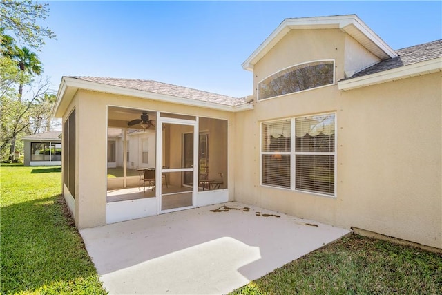 back of property featuring a patio area, stucco siding, a lawn, and a sunroom