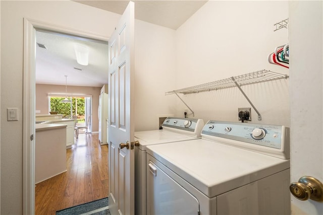 clothes washing area with laundry area, hardwood / wood-style flooring, and independent washer and dryer