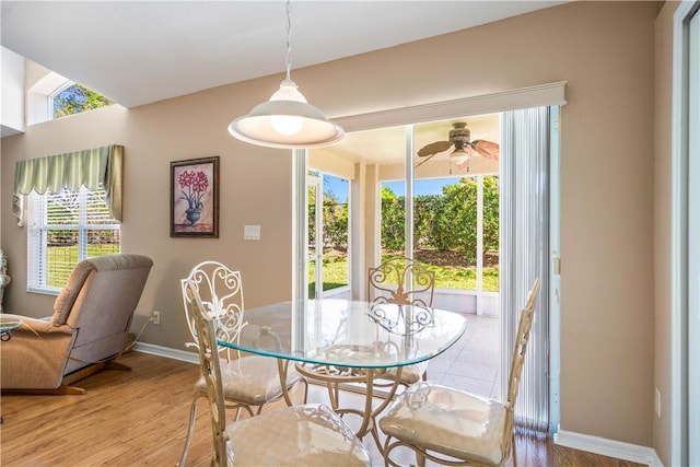 dining room with baseboards, plenty of natural light, wood finished floors, and a ceiling fan