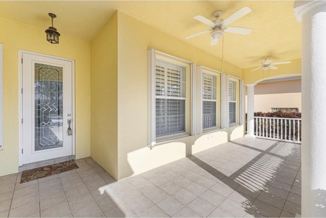 doorway to property featuring covered porch and ceiling fan