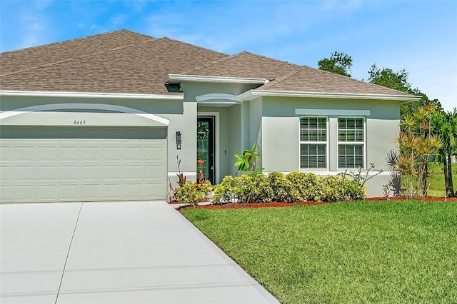8645 95th Ave, Vero Beach, FL 32967 - view of front of property with a shingled roof, an attached garage, a front yard, stucco siding, and concrete driveway