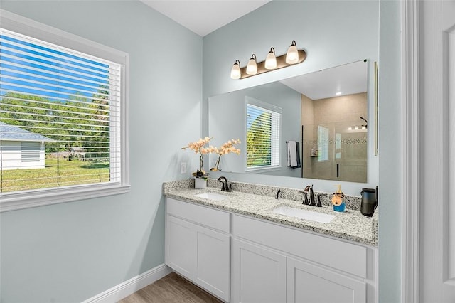 8645 95th Ave, Vero Beach, FL 32967 - full bathroom with a shower stall, double vanity, baseboards, and wood finished floors