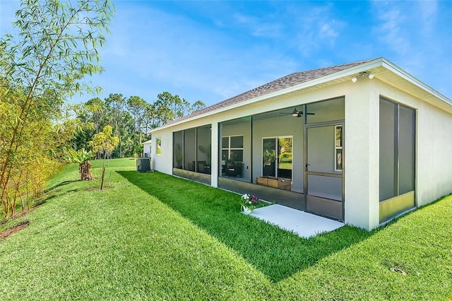 8645 95th Ave, Vero Beach, FL 32967 - back of house featuring a sunroom, a yard, stucco siding, a ceiling fan, and cooling unit