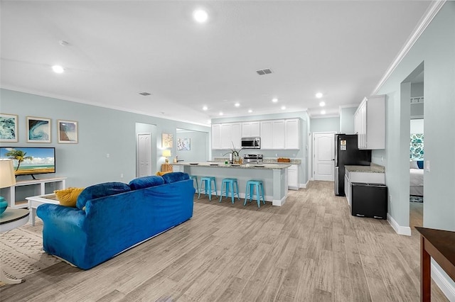 8645 95th Ave, Vero Beach, FL 32967 - living room with ornamental molding, light wood-style floors, recessed lighting, and baseboards