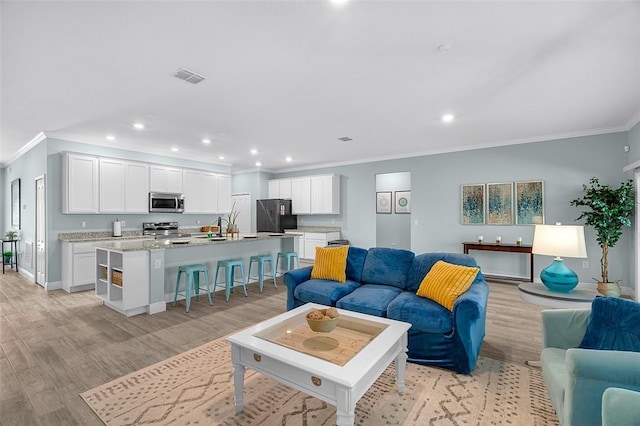 8645 95th Ave, Vero Beach, FL 32967 - living room with ornamental molding, light wood-type flooring, recessed lighting, and baseboards