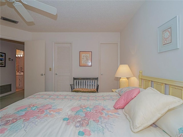 bedroom with ceiling fan, a closet, ensuite bathroom, and a textured ceiling