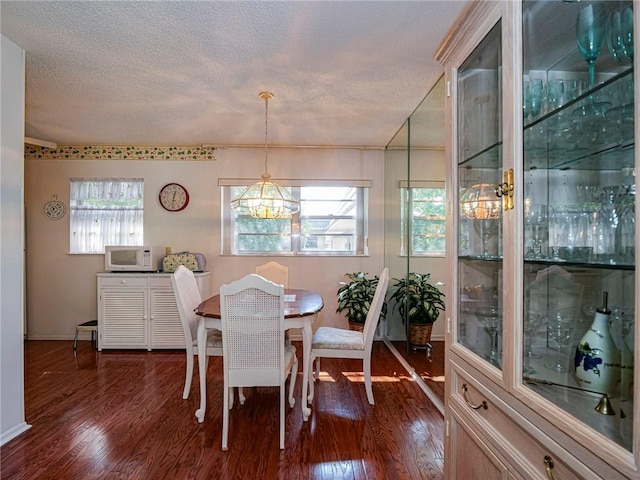 dining room featuring dark hardwood / wood-style flooring and a textured ceiling