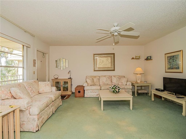 living room with ceiling fan, carpet floors, and a textured ceiling