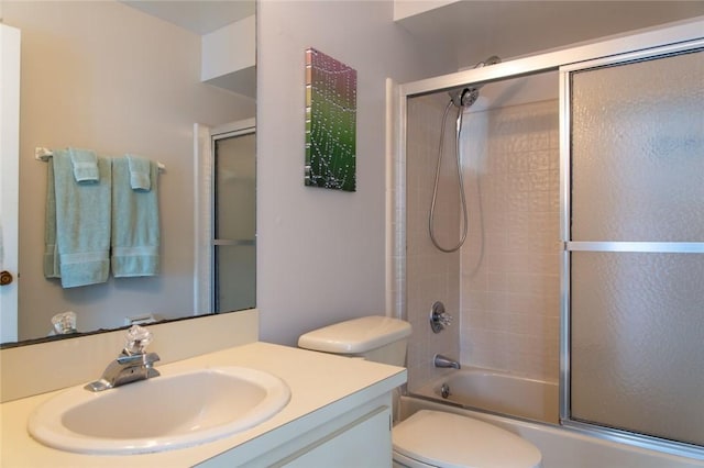 full bathroom featuring vanity, bath / shower combo with glass door, and toilet