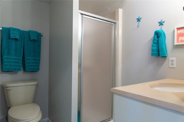 bathroom with a shower with door, vanity, and toilet