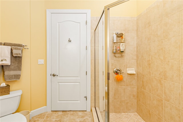 bathroom with tile patterned flooring, a shower with shower door, and toilet