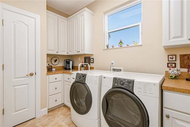 washroom with cabinets, light tile patterned flooring, and washing machine and clothes dryer