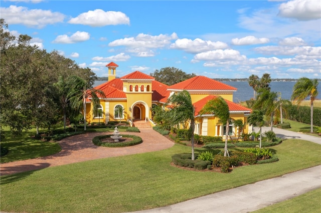 mediterranean / spanish-style home featuring a water view and a front lawn