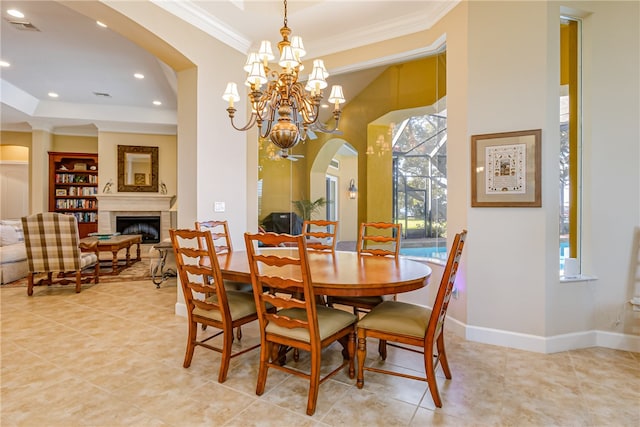 tiled dining room featuring crown molding, a tray ceiling, and a chandelier