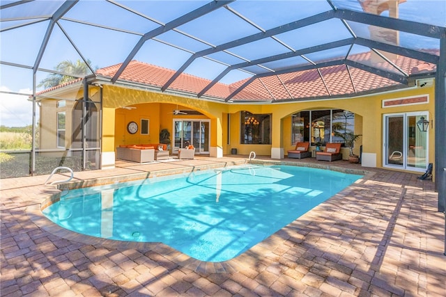 view of swimming pool with an outdoor living space, a patio, ceiling fan, and a lanai