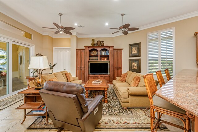 living room featuring ceiling fan, light tile patterned floors, and ornamental molding