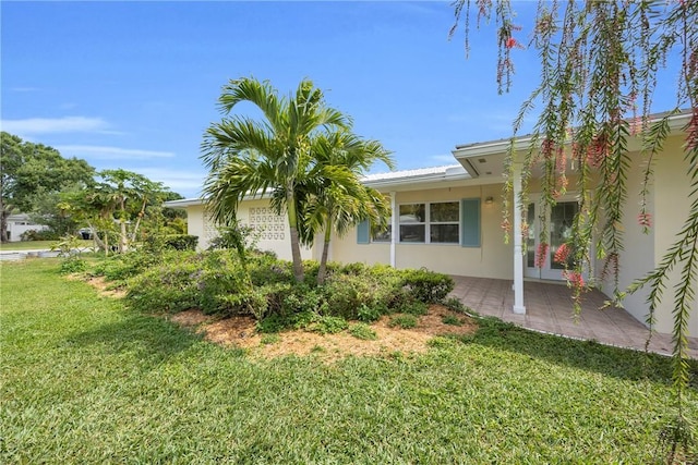 505 19th St, Vero Beach, FL 32960 - view of side of home featuring stucco siding, a yard, and a patio area