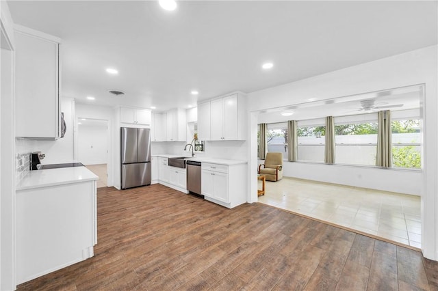 505 19th St, Vero Beach, FL 32960 - kitchen with dark wood-style flooring, light countertops, a ceiling fan, appliances with stainless steel finishes, and white cabinetry