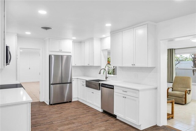 505 19th St, Vero Beach, FL 32960 - kitchen featuring white cabinets, a sink, stainless steel appliances, and light countertops