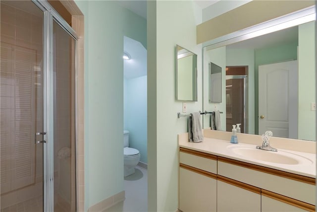 bathroom with vanity, toilet, and a shower with shower door