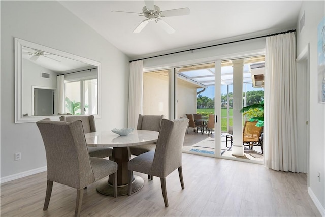 dining room with light hardwood / wood-style flooring, vaulted ceiling, and a healthy amount of sunlight