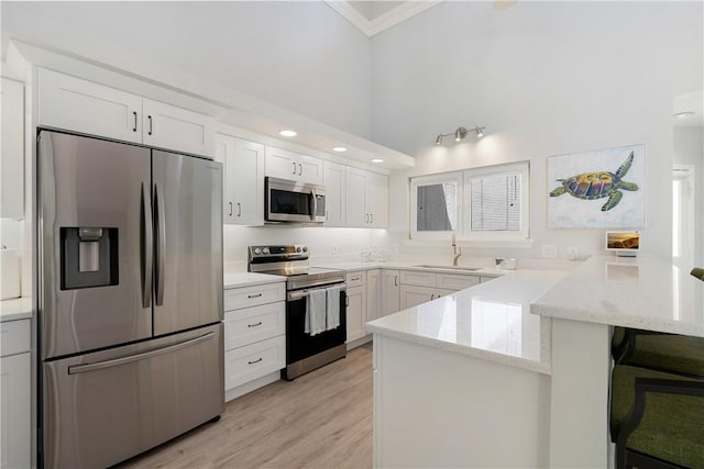 kitchen featuring white cabinetry, sink, kitchen peninsula, stainless steel appliances, and light stone countertops