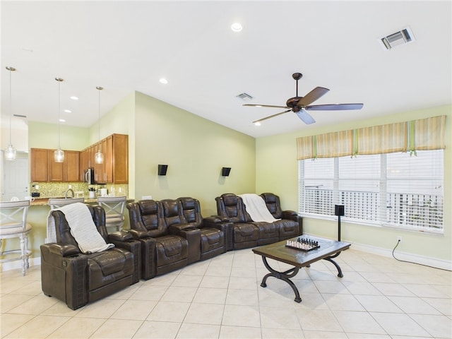 living room with light tile patterned flooring, a ceiling fan, visible vents, and baseboards