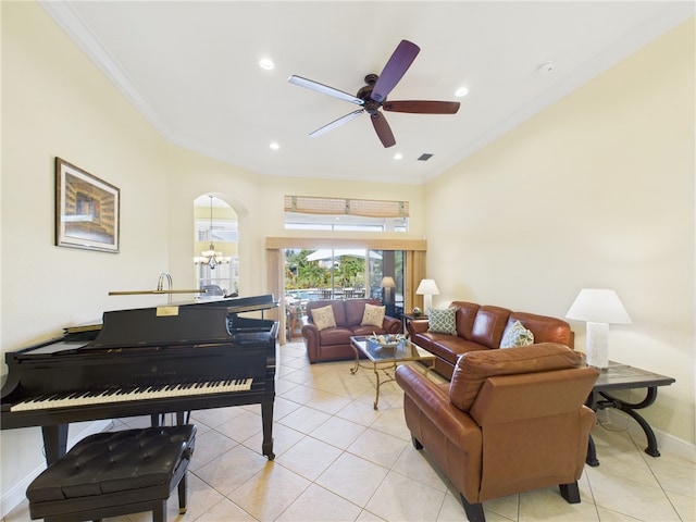 living room with light tile patterned floors, arched walkways, baseboards, and ornamental molding