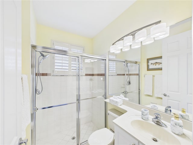 bathroom with vanity, a shower stall, and toilet