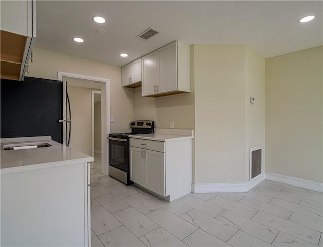 339 6th Ave SW, Vero Beach, FL 32962 - kitchen featuring stainless steel electric range oven, freestanding refrigerator, light marble finish floors, light countertops, and recessed lighting