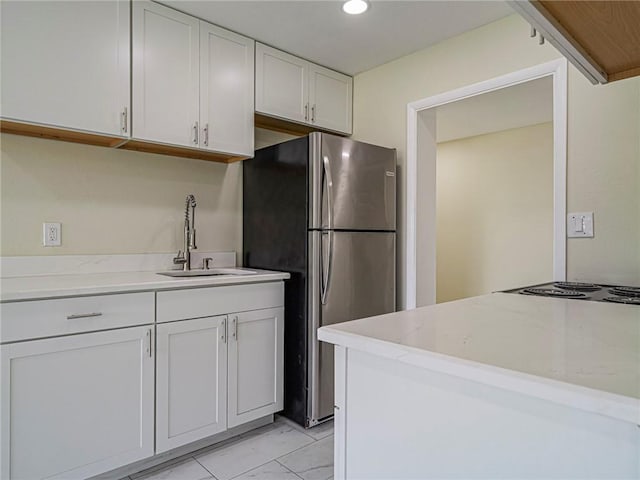 339 6th Ave SW, Vero Beach, FL 32962 - kitchen with freestanding refrigerator, white cabinets, light stone countertops, and recessed lighting
