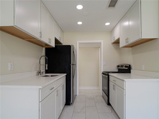 kitchen with white cabinets, appliances with stainless steel finishes, and sink