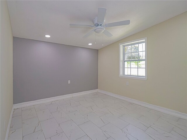 empty room with ceiling fan and vaulted ceiling