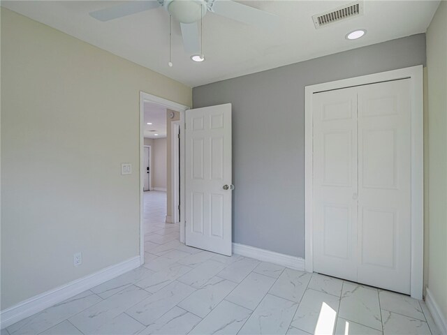 unfurnished bedroom with ceiling fan and a closet