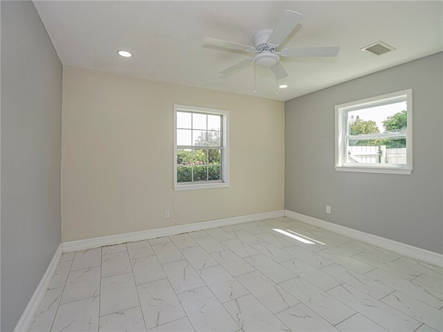 spare room with ceiling fan and a healthy amount of sunlight