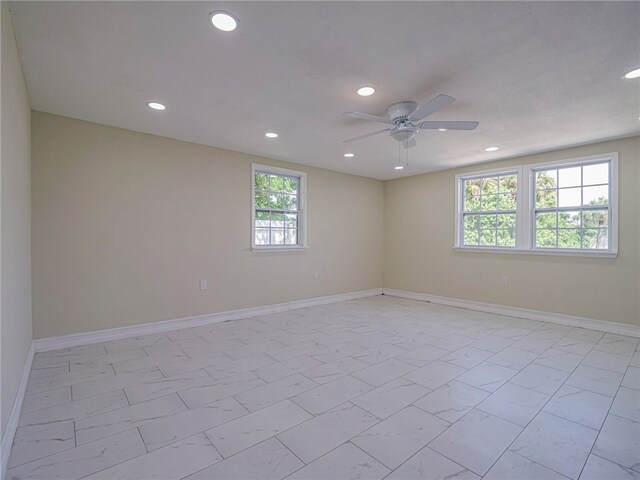 empty room with a wealth of natural light and ceiling fan