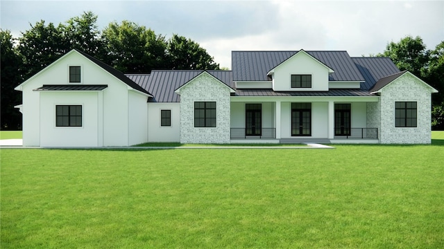 view of front of house with stone siding, metal roof, a standing seam roof, french doors, and a front lawn