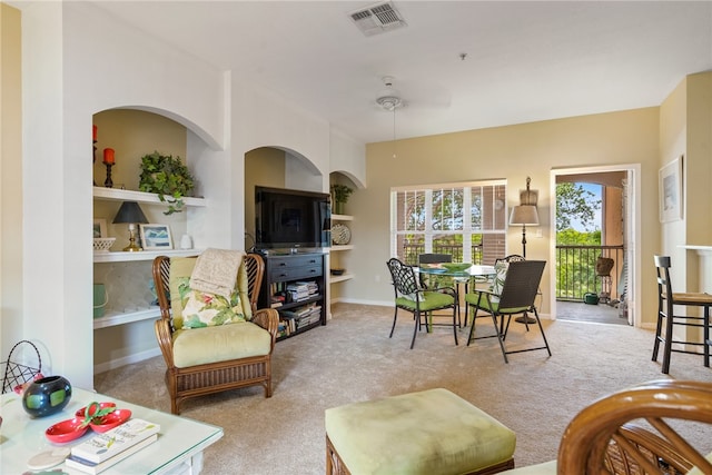 carpeted living room with ceiling fan