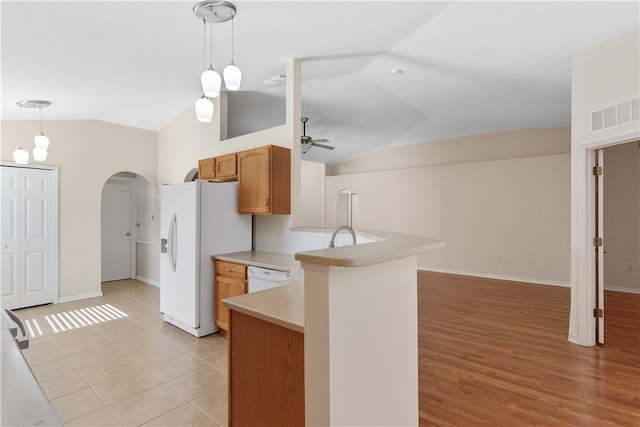 kitchen with decorative light fixtures, white appliances, lofted ceiling, and kitchen peninsula