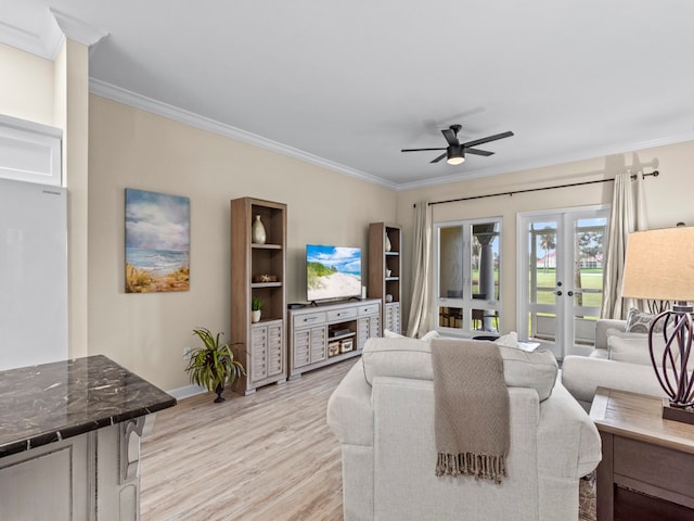 living room featuring ornamental molding, light wood-type flooring, french doors, and ceiling fan