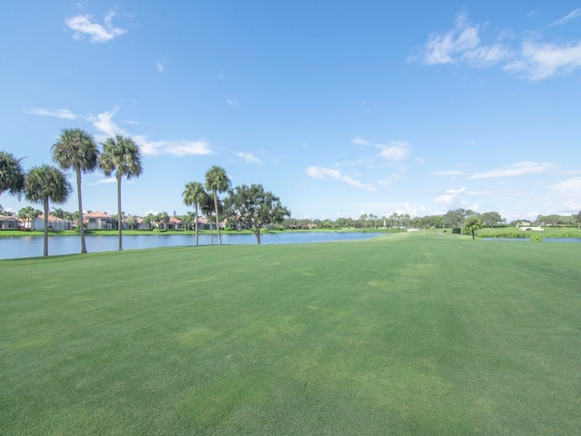 view of home's community with a water view and a lawn