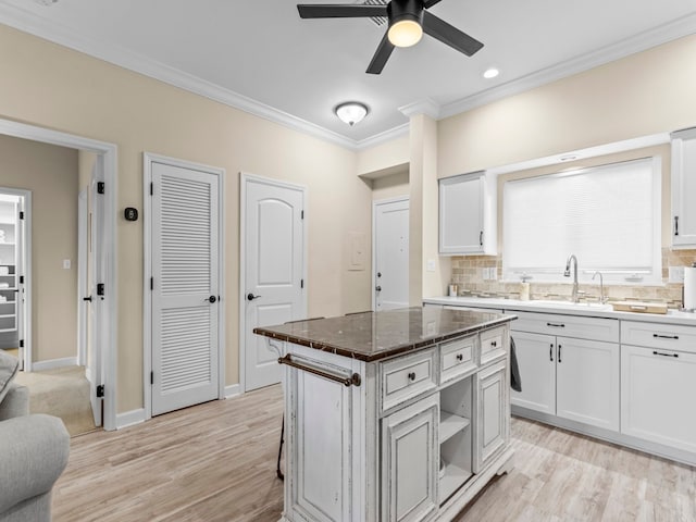 kitchen featuring white cabinetry, sink, backsplash, and a kitchen island