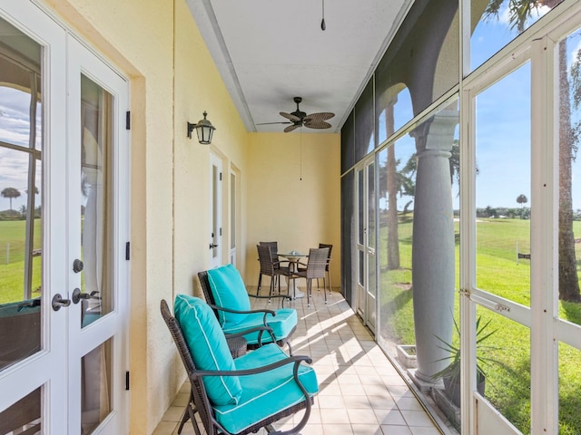 sunroom / solarium featuring ceiling fan and french doors