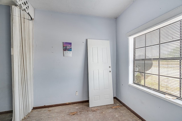 unfurnished bedroom with light wood-type flooring and a textured ceiling