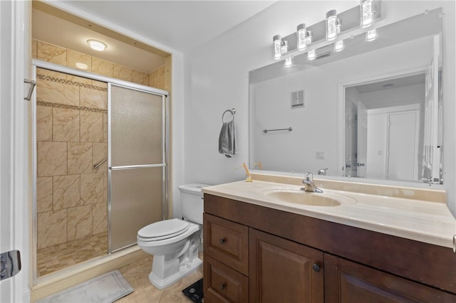 bathroom with vanity, a shower with shower door, tile patterned floors, and toilet