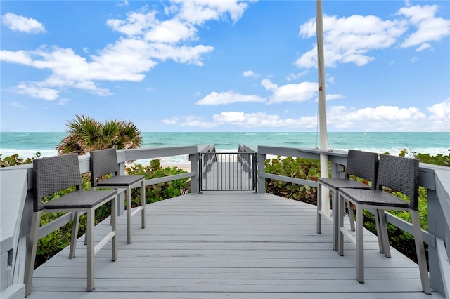 deck with a view of the beach and a water view