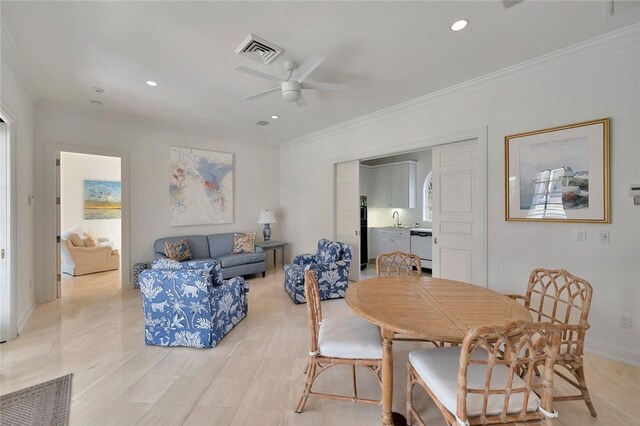 dining area featuring crown molding, sink, and ceiling fan