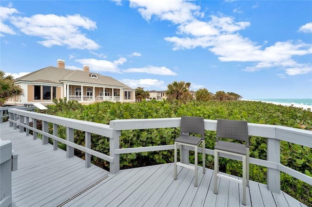 deck with a water view and a view of the beach